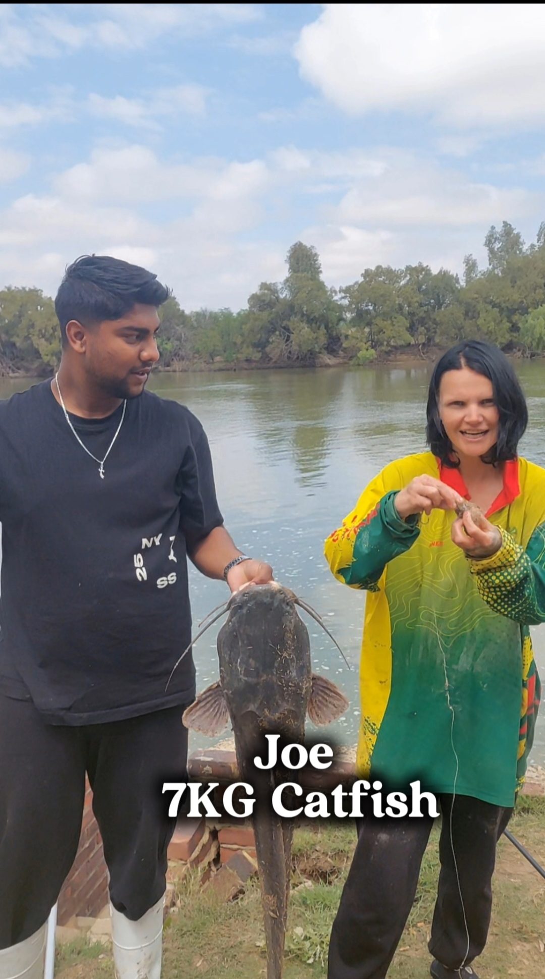 Joe holding his 7kg catfish by the river